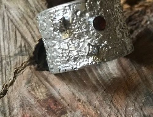 Brede zilveren ring met oorbellen erin verwerkt